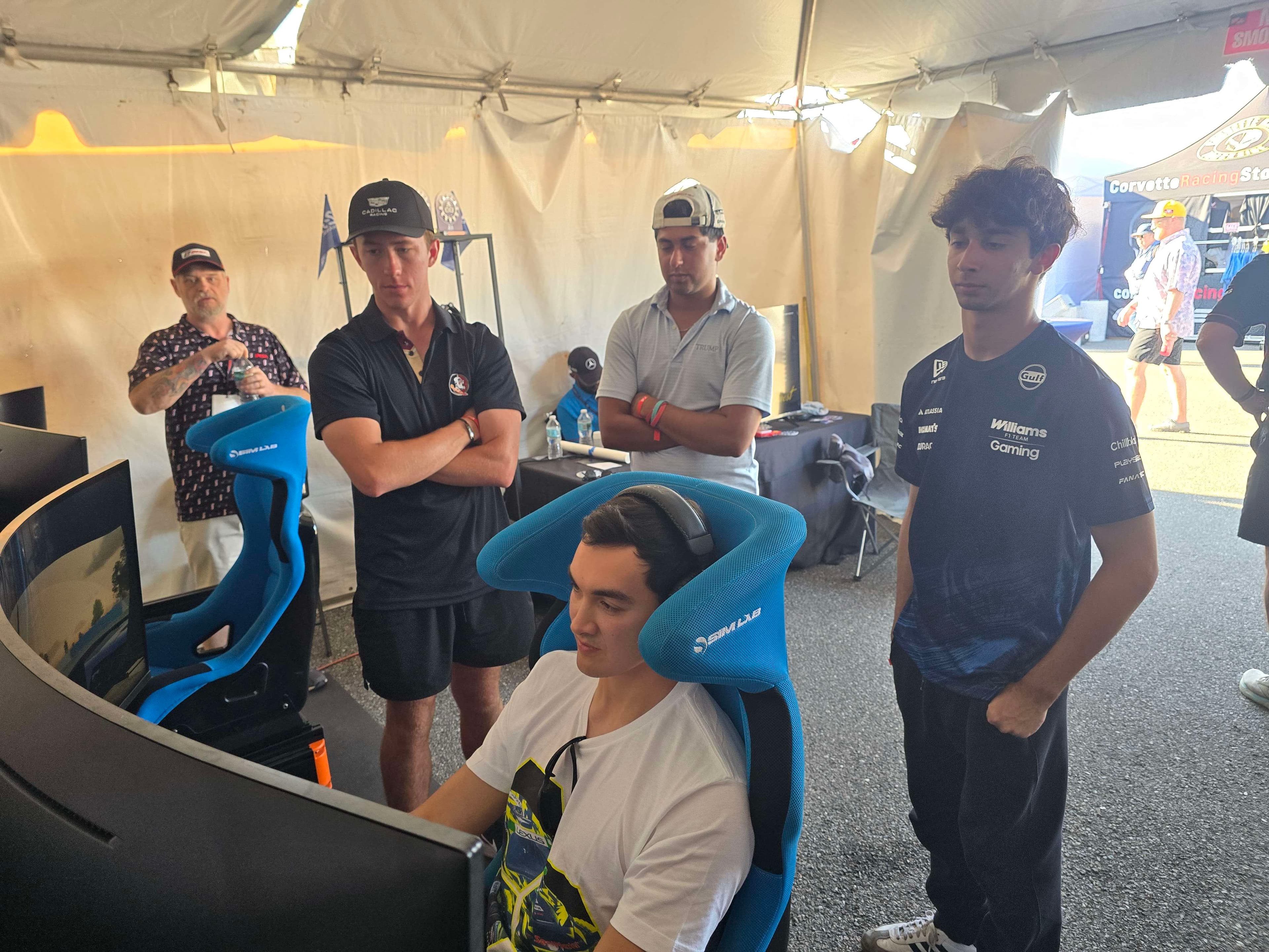 Drivers and staff watching a sim racing participant